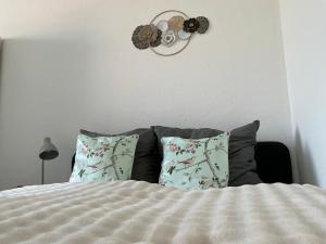 a bedroom with a bed with pillows and a clock on the wall at Harzträume Thale in Thale +7 photos