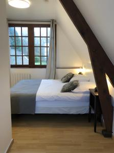 a bedroom with a bed with white sheets and pillows at Le Relais de Chasse in Eu
