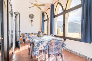 a dining room with a table and chairs and windows at Petit Palau in Port de Soller
