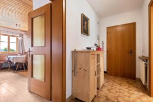 a room with a door and a kitchen with a table at Haus Thurn Apartment B in Castelrotto +23 photos