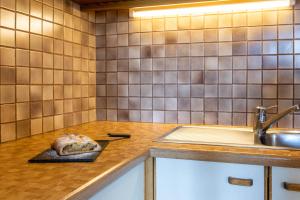 a kitchen with a counter with a sink and a cutting board at Haus Thurn Apartment B in Castelrotto