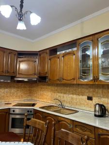 a kitchen with wooden cabinets and a sink at 3 Roots Villa in Krujë
