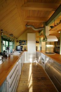 a kitchen with white cabinets and a wooden ceiling at Ferienwohnung Dina in Olbernhau