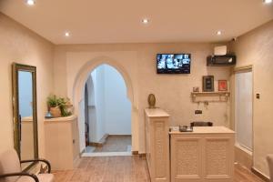 a hallway with an archway and a tv on the wall at Auberge Resto Agnaoue in Marrakesh