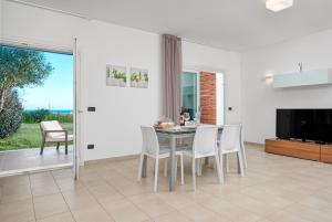 a dining room with a table and chairs and a television at Villa Marconi Apartment 5 in Golfo Aranci