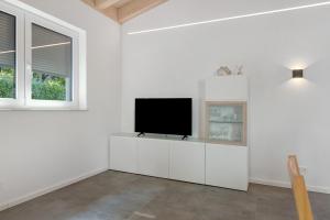 a living room with a flat screen tv on a white wall at Ferienwohnung Seeglück in Moos +20 photos
