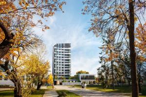 a building in a park with trees at Sofia Tech Park Apartments - Premium in Sofia
