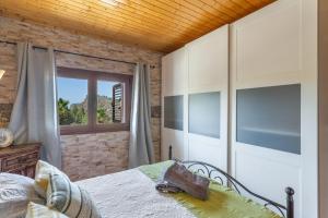 a bedroom with a bed and a window at Casa Rosi Cave House in Artenara