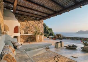 a patio with a table and a view of the ocean at Calma Beach House in Elia Beach +21 photos