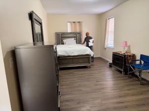 a woman standing in a bedroom with a bed at Blessed Homes in East Orange