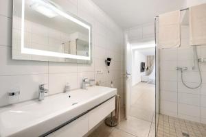 a white bathroom with a sink and a shower at Ferienwohnung Talblick in Stockach +32 photos