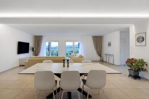 a living room with a table and white chairs at Ferienwohnung Talblick in Stockach
