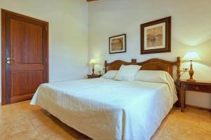 a bedroom with a large bed with a wooden headboard at Finca Antonio in Búger +12 photos