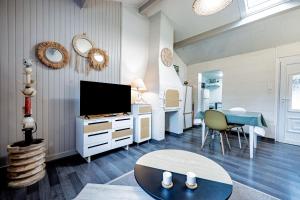 a living room with a tv and a table at Gîtes le Clos des Pradals in Tarascon-sur-Ariège
