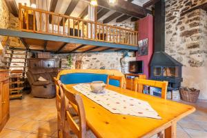a dining room with a wooden table and a fireplace at Ca La Germandat Paüls in Paúls