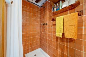 a bathroom with orange tiles and yellow towels at Ca La Germandat Paüls in Paúls +21 photos