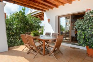 a wooden table and chairs on a patio with a potted plant at Can Marsá de Baix in Santa Eularia des Riu