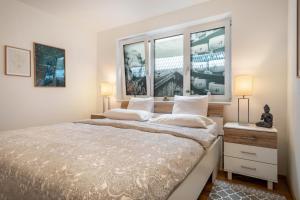 a bedroom with a large bed with two windows at Ländle Lodge bei Bregenz in Langen bei Bregenz