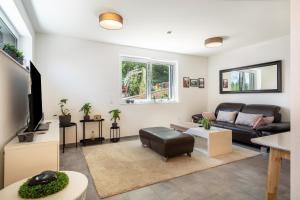 a living room with a couch and a tv at Ländle Lodge bei Bregenz in Langen bei Bregenz