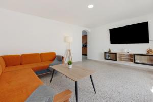 a living room with a couch and a flat screen tv at Edificio El Baifo Loco - Milena in Gran Tarajal