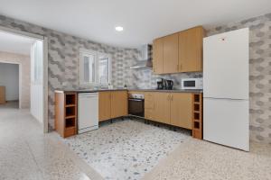 a kitchen with wooden cabinets and a white refrigerator at Edificio El Baifo Loco - Milena in Gran Tarajal