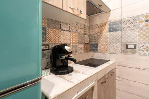 a small kitchen with a sink and tiles on the wall at Dimora Donna Lucrezia in Mola di Bari +12 photos