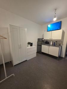 a room with a kitchen with white cabinets and appliances at Relax after work in Ochsenhausen