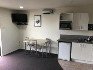 a kitchen with a table and chairs in a room at Kiwi Court Motel in Hawera