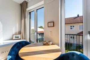 a table and chairs in a room with a large window at Terralpin Apartments - 27qm in Bruckmühl