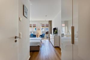 a bedroom with a bed and a living room at Terralpin Apartments - 27qm in Bruckmühl