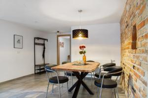 a dining room with a brick wall and a wooden table and chairs at Felicitas in Tann