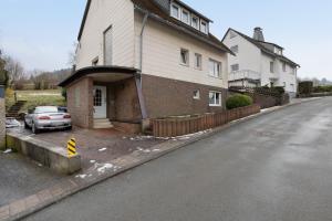 a house with a car parked on the side of the road at Fewo Kerbe in Willingen