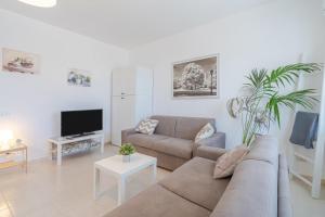 a living room with a couch and a tv at Villa Clara in Gallina