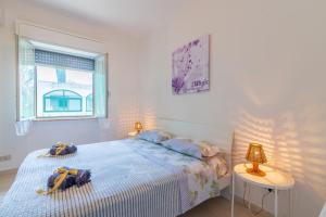 a white bedroom with a bed and a table at Villa Clara in Gallina