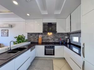 a kitchen with white cabinets and a sink at Lavender Residence in Kuşadası