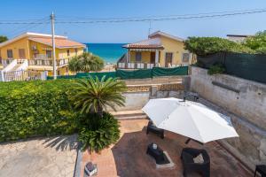 a white umbrella sitting on a patio near the ocean at Villa Clara in Gallina