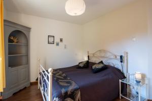 a bedroom with a bed with a blue comforter at Maison Iris in Castelnaud La Chapelle