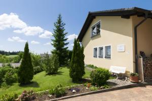 a house with a garden with a bench and trees at Haus Höhensonne in Höchenschwand