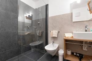 a bathroom with a shower and a toilet and a sink at Thusnelda Apartment D in Siusi