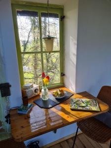 a wooden table with a vase of flowers and a window at Pepper Huis in Lemgo