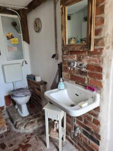 a bathroom with a white sink and a toilet at Pepper Huis in Lemgo