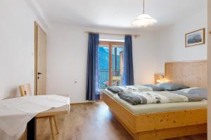 a bedroom with a bed and a table and a window at Thusnelda Apartment D in Siusi