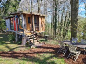 a tree house in the woods with a table and chairs at Pepper Huis in Lemgo