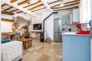 a kitchen and living room with wooden ceilings and a table at Cueva Secreta Güejar in Güéjar-Sierra