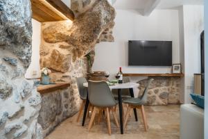 a dining room with a table and chairs and a tv at Cueva Secreta Güejar in Güéjar-Sierra