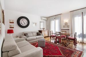 a living room with a couch and a clock on the wall at Apartment Bossi View in Chiavenna