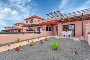 a house with a patio with a table and chairs at Villa Asensio in Lajares