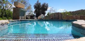 a large swimming pool with blue water in a yard at Cortijo la Era in Castril