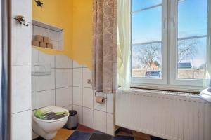a bathroom with a toilet and a window at Gutshaus Meerzauber in Altenkirchen +28 photos