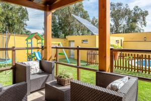 a patio with a playground with chairs and a swing at Casa rural la cabaña in Vejer de la Frontera